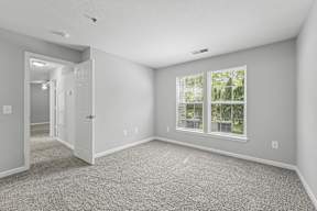 A room with a window and carpeted floor